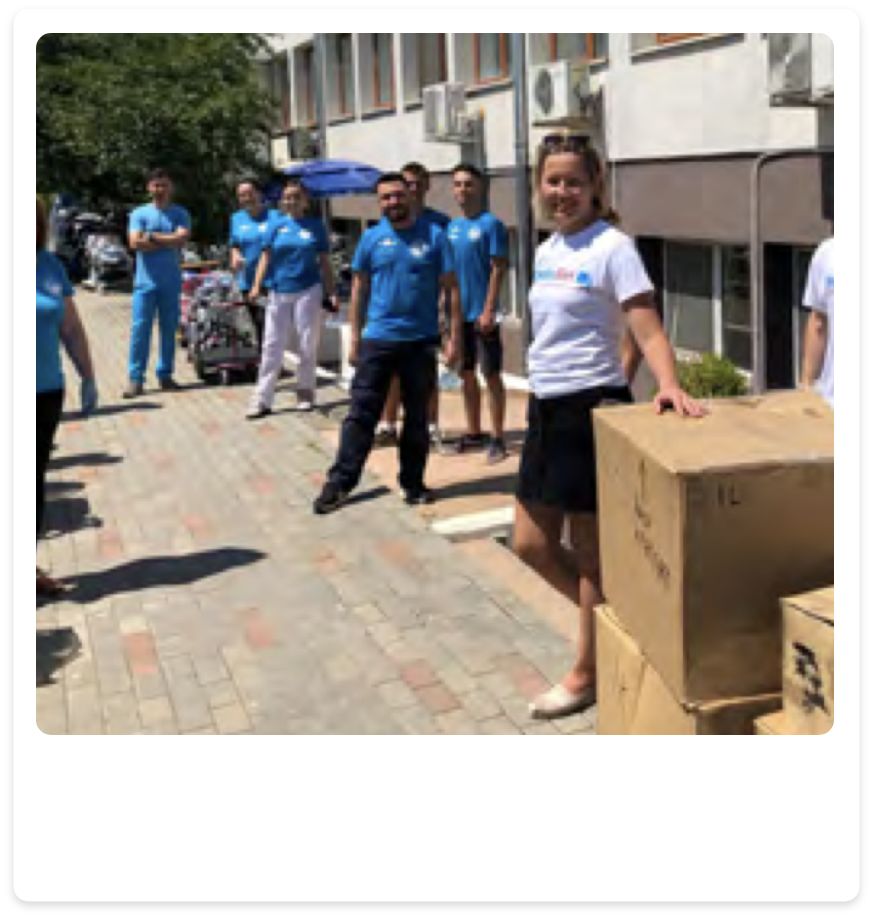 Phyisionet volunteers with healthcar workers receiving boxes of equipment